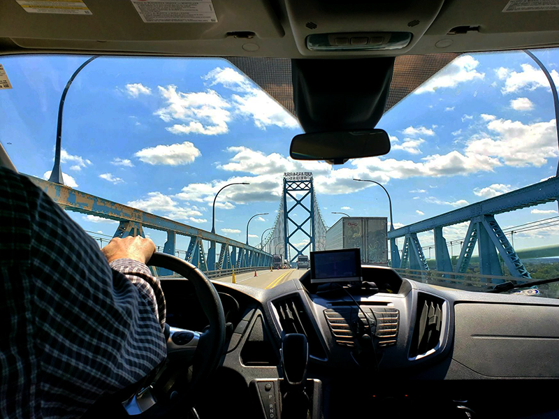 Crossing the Ambassador Bridge into Canada. — with Karen Jacobsen - The GPS Girl and Jeremy Porter at Detroit Riverfront.